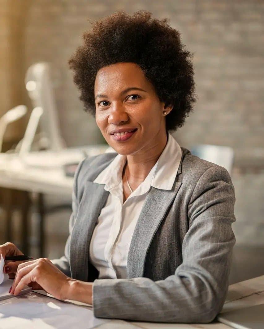 A smiling Aigle adviser at her desk with a client file