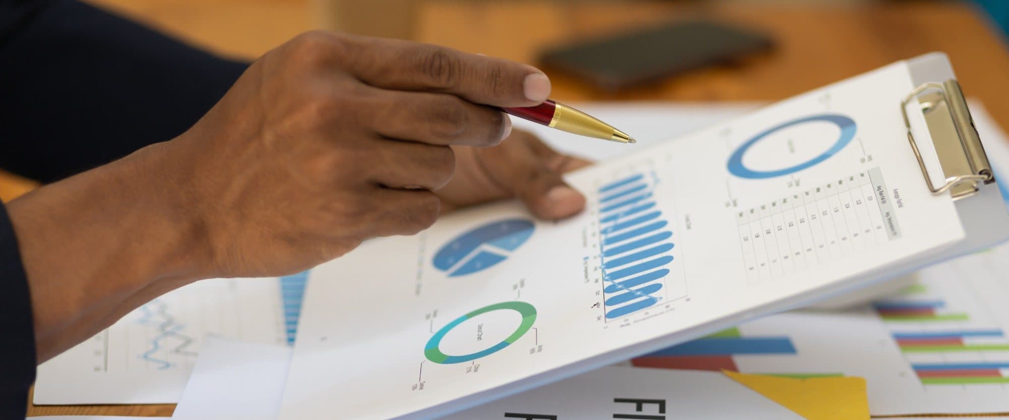 An adviser pointing to a chart in a printed financial report